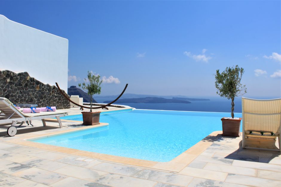 A bright, modern luxury villa featuring a clean-lined infinity pool that seamlessly blends into the horizon of the blue ocean, symbolizing the aspirational real estate in Cabo.